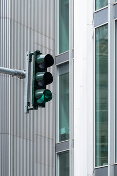 A green traffic signal shines brightly against a backdrop of sleek, modern architecture, symbolizing progress and direction in urban settings.