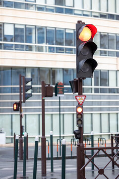 A vibrant red traffic light stands out at a busy urban intersection, highlighting the constant movement of city life while designed with a modern aesthetic.