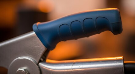 Detailed view of a mechanical clamp with ergonomic blue handle design