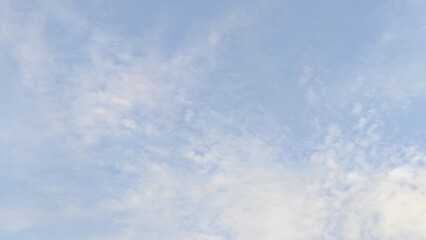 Bright blue sky with fluffy white clouds, a beautiful summer cloudscape reflecting clear light and sunlight