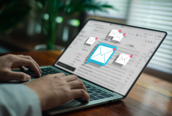 person typing on a laptop with multiple new email notification icons represents digital communication, online information management, productivity, and the fast-paced workflow of a modern technology.