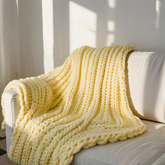 Isolated butter yellow knitted throw blanket with chunky yarn texture, soft shadows on white background, creating a cozy and tactile home atmosphere