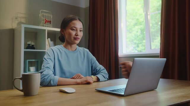 Asian woman see thump up remotely, thumbup like ok from laptop screen. Approval at home. Female employee virtual meeting. Successful distant interview. Girl good job video call. Work deal conference.