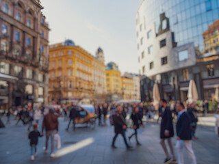 Crowd of anonymous people walking on busy city street	