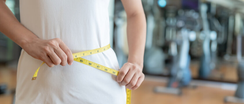 Diet and dieting. Beauty slim female body use tape measure. Woman in exercise clothes achieves weight loss goal for healthy life, crazy about thinness, thin waist, nutritionist. Fitness