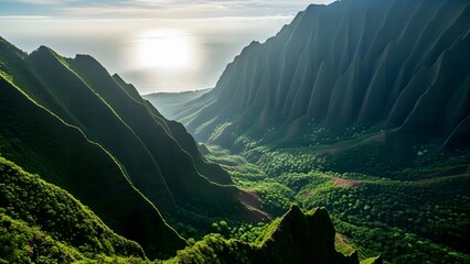 Lush green valley with dramatic mountain ridges sun shining over the ocean aerial view of tropical l