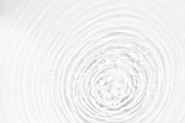 White water with ripples on the surface. Defocus blurred transparent white colored clear calm water surface texture with splashes and bubbles. Water waves with shining pattern texture background.