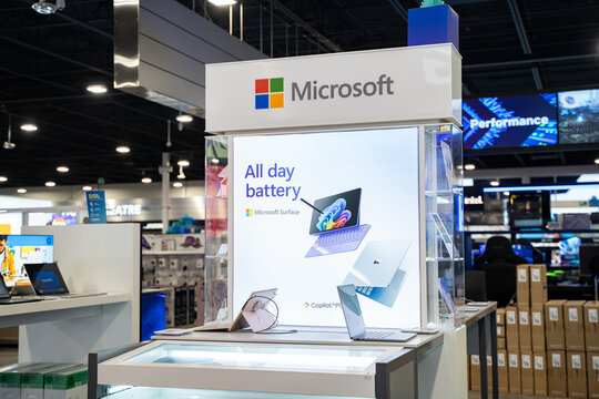 Display of Microsoft Surface laptops and promotional signage in store. Toronto, Canada - December 3, 2025.