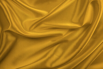 Obraz premium An abstract, luxurious background of rich, golden-yellow silk fabric draped with soft, flowing folds.