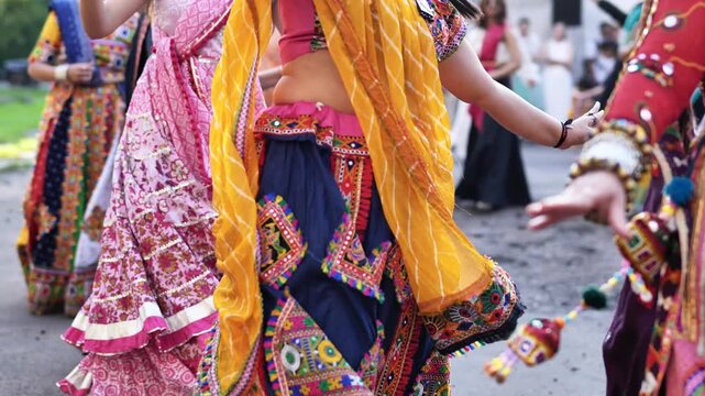 Women performing Garba dance at Ganesh Chaturthi festival, wearing colorful traditional lehengas