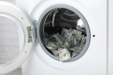 Many dollar banknotes in washing machine, closeup