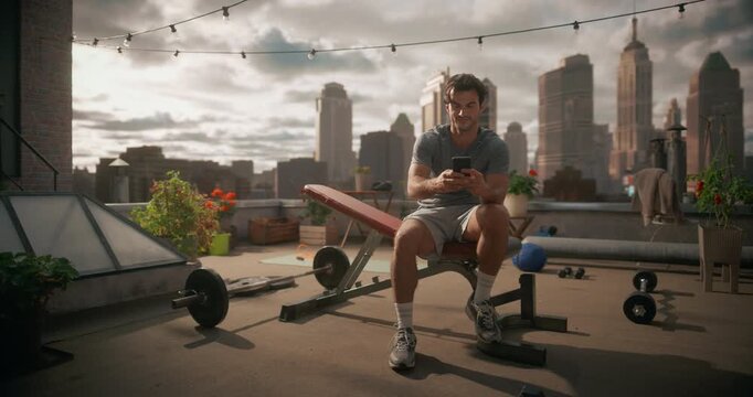 Fit Man in Gray Workout on Rooftop City Gym, Using His Smartphone Fitness App to Film Exercise Content, Share Progress on Social Media, Monitor Heart Rate, Healthy Performance Data Online 