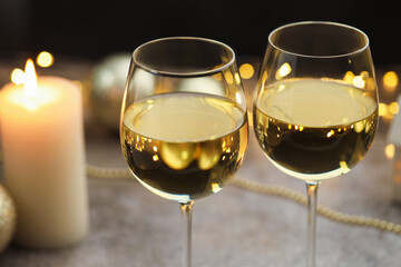 Glasses of white wine and Christmas decor on gray table, closeup