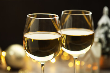 Glasses of white wine against blurred background, closeup. Christmas and New Year celebration