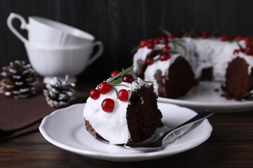 Tasty Christmas cake with cranberries and rosemary served on wooden table, closeup