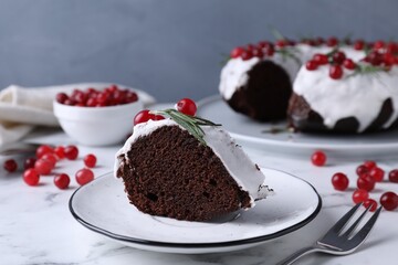 Tasty Christmas cake with cranberries and rosemary served on white marble table, closeup