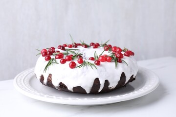 Tasty Christmas cake with cranberries and rosemary on white table, closeup