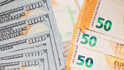Stacks of US hundred dollar bills and euro fifty banknotes arranged side by side, representing international finance, global currency, business transactions, and economic exchange.