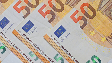 Closeup view of euro banknotes arranged in an overlapping pattern, showcasing European money for financial backgrounds.