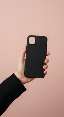 Hand holding a black smartphone case against a pink background