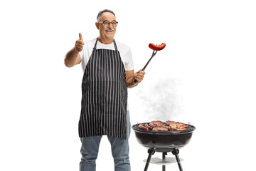 Mature man holding a bbq sausage with a fork