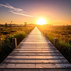 Wooden boardwalk stretching into a vibrant sunset over a marshland landscape.