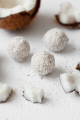 Coconut sweets with chocolate on a light wooden background. Natural sweets without sugar.