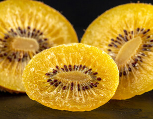 Dried golden kiwi fruit slices isolated on a black background