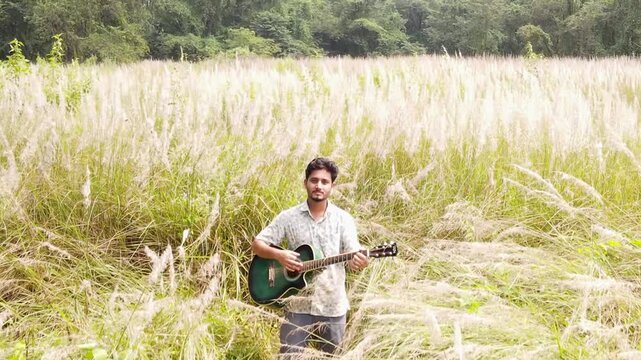 Man Playing Guitar On Kashful Field In Nature - Drone Shot