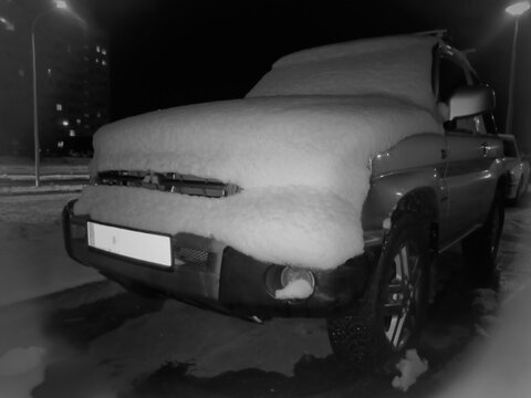 Polska, Ostrowiec Świętokrzyski, 24 listopada 2025, 20:06. Mitsubishi Pajero Pinin pokryty grubą warstwą puszystego śniegu, oświetlone światłem podczerwonym, nocą na ulicy w Ostrowcu Świętokrzyskim. 