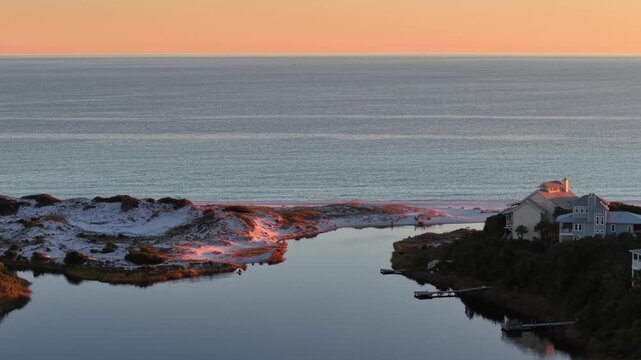 Beautiful late sunset reflecting on Gulf at Draper Lake endpoint with calm coastal dunes, Old Florida Beach, Florida, USA