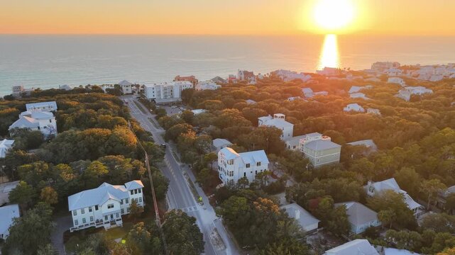 Panoramic drone view over beautiful sunset in glowing horizon at coastal Gulf neighborhood, 30A, Florida, USA