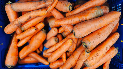 Sale of washed carrots in plastic boxes. Sale of carrots, selective focus. Vegetables in a supermarket close-up.