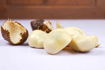 Close-up of peeled snake fruit with brown scaly skin on table