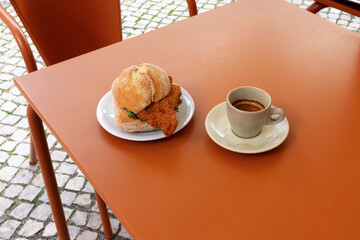 Sandwich and espresso outdoor cafe table. Casual dining, local cuisine, and slow travel moments