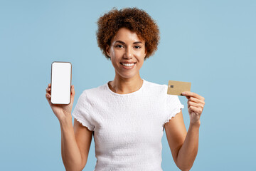 Woman presenting smartphone with blank screen and credit card for mobile payment