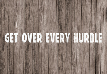 The inscription &laquo;get over every hurdle&raquo; on old wooden boards