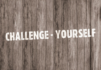 The inscription «Challenge yourself» on old wooden boards