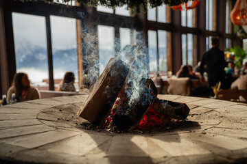 żarzący się ogień na kawałkach drewna ogrzewający wnętrze pomieszczenia w zimowe popołudnie © siwyk