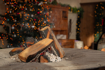 kawałki palącego się drewna na tle ozdobionego drzewka bożonarodzeniowego © siwyk