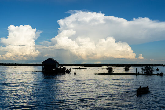 Floating village on Tonle Sap Lake with boats and dramatic cloudscape