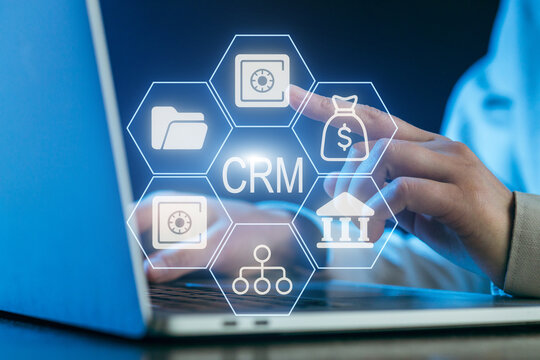 Business professional using CRM software on laptop while analyzing data at night