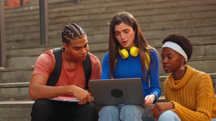 Multiethnic students collaborating on laptop project outdoors - Powered by Adobe