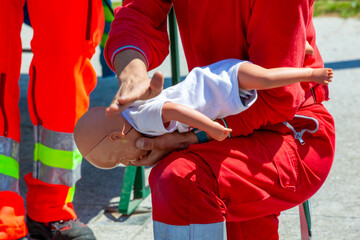 Rescuer performing first aid training on infant manikin