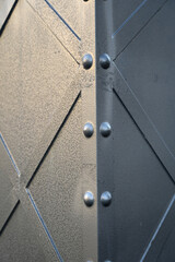 Textured metal corner with rivets showing detail and craftsmanship close up