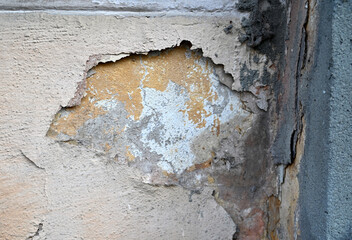 Peeling paint on an old building wall reveals layers of history and texture in an urban setting