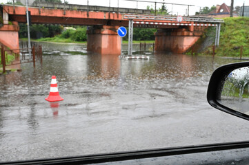 Heavy rain causes flooding under bridge in urban area during afternoon