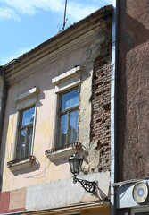 Historic building in need of repair shows weathered facade and exposed brick in a vibrant urban setting