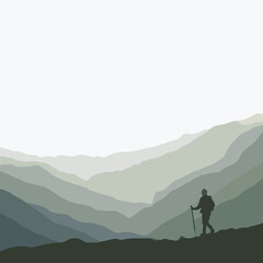 Hiker standing on mountain ridge against misty green landscape  