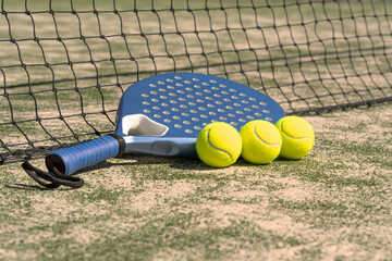 Close-up padel rackets and bright tennis balls on an outdoor court near the net. Sport gear in sunlight with selective focus, capturing active lifestyle and modern sportlife.